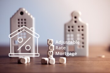 ARM (Adjustable Rate Mortgage) - acronym Concept with miniature houses in the background.