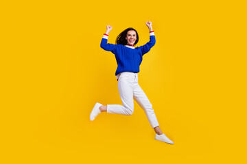 Fototapeta na wymiar Full length body photo of successful brunette woman raise fists up celebrate new collection clothes isolated on yellow color background