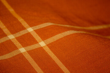 A beautiful sharp orange color Kain Pelikat or Kain Sarong with stripe forming a square shape. A traditional fabrics from Malaysia.
