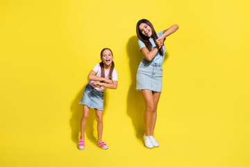Photo of positive excited girls dance on school party isolated over bright color background