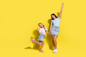 Photo of two positive girls cousins have fun together isolated over bright color background