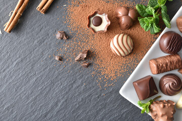 Chocolate bonbons on plate on a slate with cinnamon