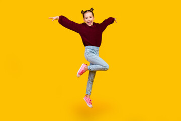 Fototapeta na wymiar Full size photo of cheerful adorable girl jumping have good mood isolated on yellow color background