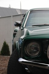 Close up image of an emerald green vintage car with a clean tire in the foreground