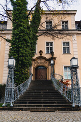 The main entrance to the palace in Krzyzowa with stairs and lanterns and vines in autumn colors. - obrazy, fototapety, plakaty