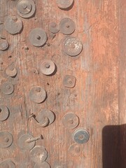 a wooden gate decorated with old coins at Old Junga Palace, Himachal Pradesh, India