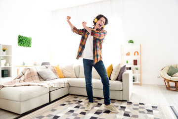 Full length photo of cheerful good mood guy dressed checkered shirt dancing listening music headphones indoors house home room