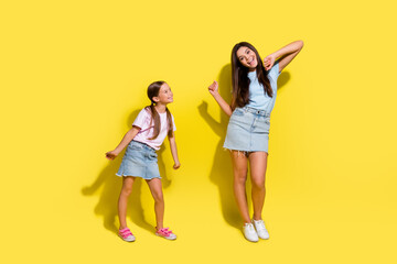 Photo of two positive girls older sister dancing teaching younger isolated over vivid color background