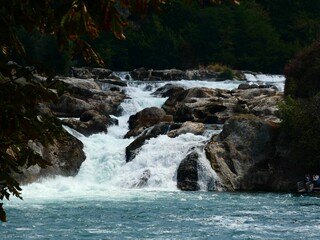 Tranquil mountain river cuts through a rocky valley, creating a cascading stream