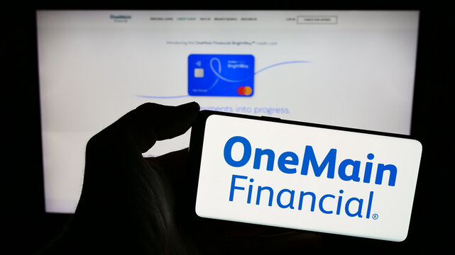 Stuttgart, Germany - 02-03-2024: Person holding smartphone with logo of US financial services company OneMain Holdings Inc. in front of website. Focus on phone display.