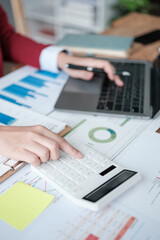 Close up of woman busy paying bills online on computer calculating household finances or taxes on machine, female manage home family expenditures, using calculator, make payment on laptop