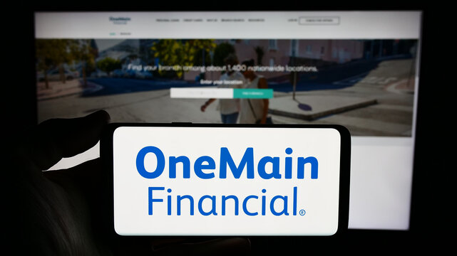 Stuttgart, Germany - 02-03-2024: Person holding cellphone with logo of US financial services company OneMain Holdings Inc. in front of business webpage. Focus on phone display.