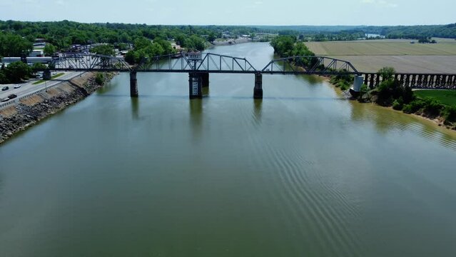 Aerial of a wide calm river with a bridge in the background during the daytime