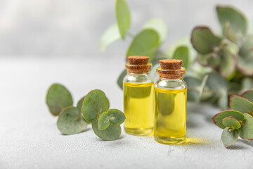 Eucalyptus essential oil in a glass bottle with green eucalyptus leaves on a textured wooden background. Aromatherapy concept. Spa. Natural organic ingredients for cosmetics and body care.Copy space