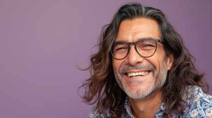 Smiling man with long hair and glasses wearing a patterned shirt against a purple background. - obrazy, fototapety, plakaty
