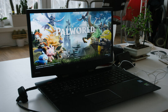 BERLIN, GERMANY - FEB 9, 2024: Teenager playing Palworld game released earlier this year on a Windows laptop at home