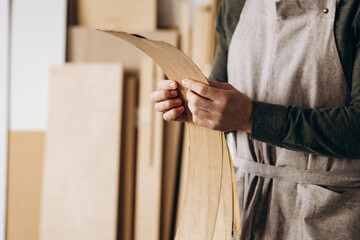 Carpenter holding veneer at the working place