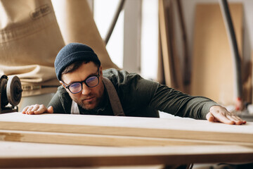 Carpenter working with wood and saw in the manufacturing industry