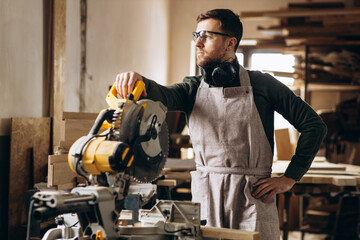 Carpenter working with wood and saw in the manufacturing industry