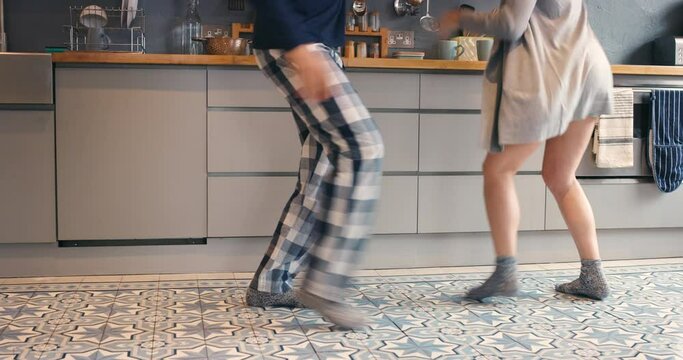 Couple, dancing and people legs in kitchen with love, morning and music in home. Happy, feet and support in a house with pyjamas with bonding, excited and freedom from audio with energy and care