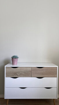 Modern nordic style dresser with flower pot on it in front of clean wall