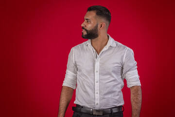 Man, with a beard, in a white shirt, with various facial expressions, on a red studio background