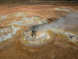Inside a big crater of an active volcano with gray-white smoke coming out, aerial view. Earth,...