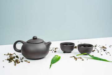 Black teapot and cups with bamboo leaves on a tray. Traditional tea ceremony. Green Tea Composition...