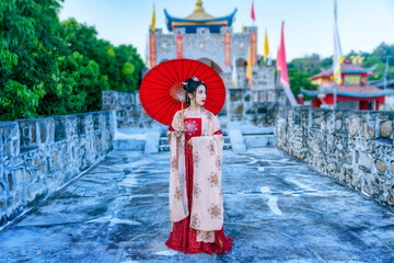 Fototapeta na wymiar Asian woman wearing a red Chinese culture dress visit Santichon Village, Pai, Mae Hong Son province, Thailand.