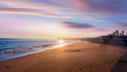 A Colorful Ocean Sunset Sky as a Gentle Wave Rolls in Santa Barbara Harbor Marina Ships Bay California,