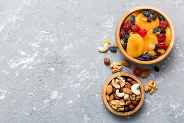 Obraz na płótnie Canvas healthy snack: mixed nuts and dried fruits in bowl on table background, almond, pineapple, cranberry, cherry, apricot, cashew