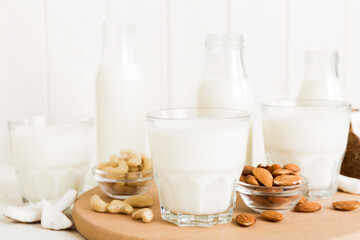 Set or collection of various vegan milk almond, coconut, cashew, on table background. Vegan plant based milk and ingredients, top view