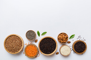 Various superfoods in smal bowl on colored background. Superfood as rice, chia, quinoa, lentils, nuts, sesame seeds, almonds. top view copy space