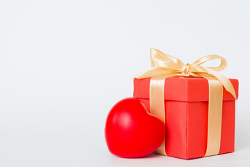 gift box with red bow and red heart on colored background. Perspective view. Flat lay