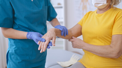A traumatologist reviews a patient's wrist following serious injury treatment, focusing on recovery - obrazy, fototapety, plakaty