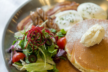 View of pancakes, sausages and vegetables on the plate in the restaurant