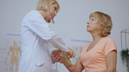 A traumatologist removes a cast from a patient's arm, revealing a healed hand, signifying recovery