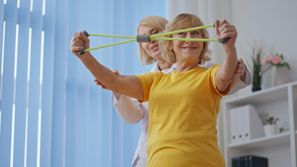A senior patient stretches at a rehabilitation clinic, practicing spinal cord injury exercises