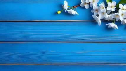 Cherry flowers on a blue wooden background, top view. Spring background.