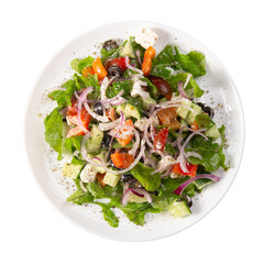 Traditional greek salad with fresh ingredients, feta cheese, olives, red tomatoes, cucumbers and greens in white plate, isolated on white background. Top view, close up, copy space.