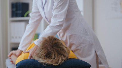 A woman with shoulder pain visits a doctor, seeking a rehabilitation physician for trauma