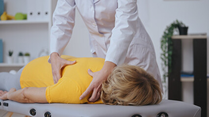 A traumatologist examines a patient, focusing on shoulder surgery rehabilitation and disorder