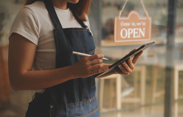 Startup successful small business owner sme beauty girl stand with tablet smartphone in coffee shop...