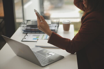 Shot of a asian young business Female working on laptop in her workstation.