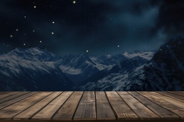 Naklejka na ściany i meble Empty wooden deck table against view of snowy mountain range in the night. With space for the product