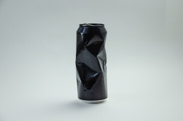 Crumpled aluminum black can on light background