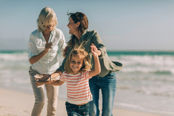 Three generations of women having fun on the beach