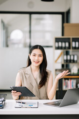 Asian Businesswoman Analyzing Finance on Tablet and Laptop at modern Office Desk tax, report,