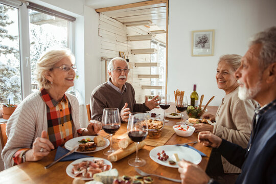 Diverse senior people eating lunch together at home