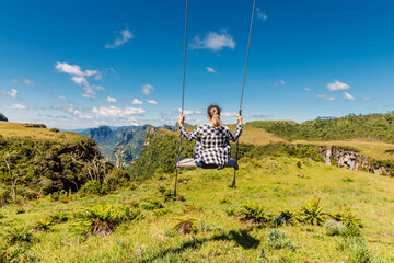 Hiker woman on a swing in Canyon park in Santa Catarina, Brazil.